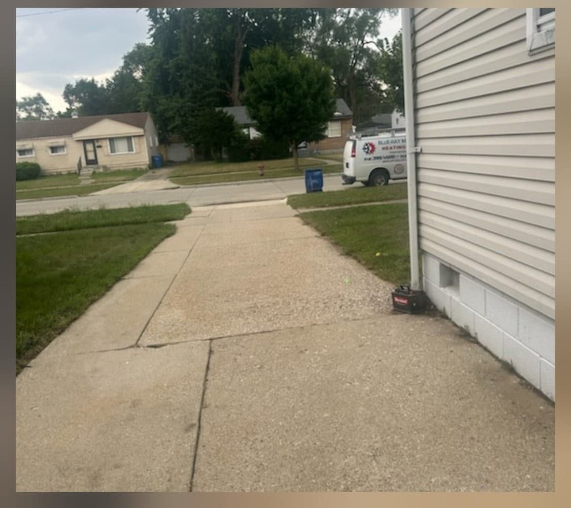 Concrete driveway and curb bright and clean after professional surface cleaning